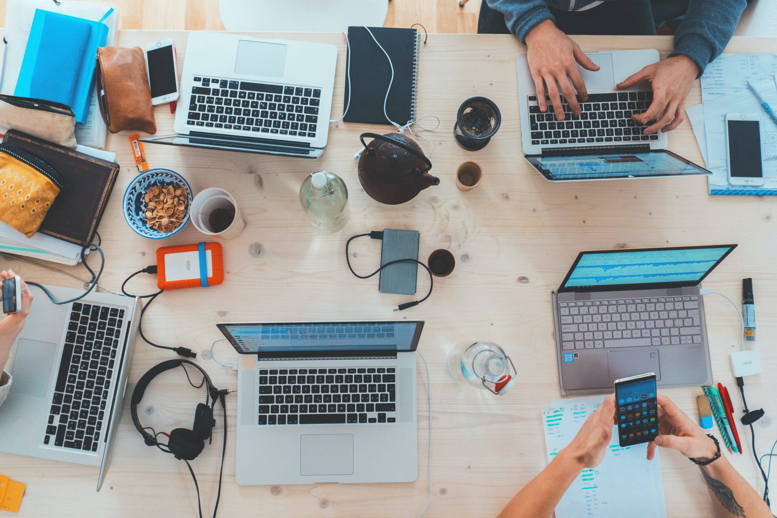 overhead view of laptops and phones on table.