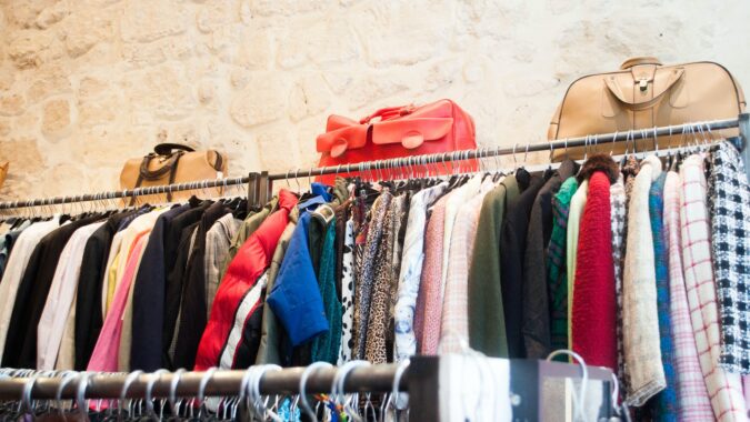 clothes on charity shop rail.