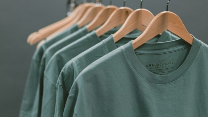 green t-shirts on hangers.